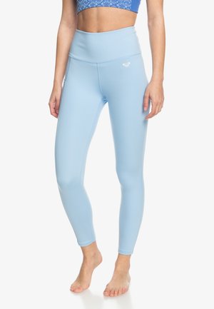 Light blue high-waisted leggings made of smooth, stretch fabric. Features a subtle brand logo on the front and fitted design.