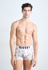 Men's boxer shorts in a light pastel design featuring cat faces; elastic waistband with "DIESEL" brand logo in black. Material appears soft and stretchy.