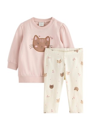 Vaaleanpunainen pitkähihainen pikkutytön paita, jossa on suuri kissan kasvot -kuvio, ja kermanväriset legginsit, joissa on pieniä kissoja, sydämiä ja kirsikoita.