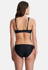 Zwarte bikini set met een gestructureerd ruitpatroon, verstelbare bloemmotiefbandjes en een middenhoog bottom met een gladde afwerking.