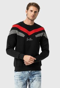 Zwarte sweatshirt met rode en grijze chevronontwerpen, geribbelde mouwen en zoom. Voorzien van geborduurd logo op de borst. Zachte katoenmix stof.