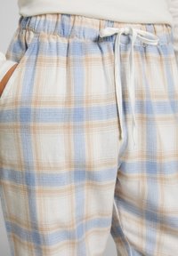 Katoenen geruite broek met een relaxed fit, voorzien van een witte trekkoord, lichtblauwe en beige blokken, en zijzakken. Zachte textuur.