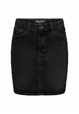 Woman wearing a pink sleeveless top, black studded mini skirt with belt, tall black boots, holding a bright pink cylindrical handbag.