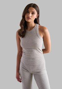 Top a maniche corte grigio a costine con scollatura rotonda e design aderente, abbinato a leggings coordinati a costine. La texture sembra morbida ed elastica.