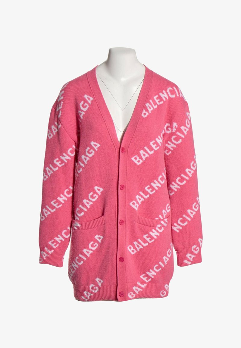 Cardigan rose vif avec boutons sur le devant, deux poches, et motif de texte blanc répété "BALENCIAGA" sur tout le tissu.