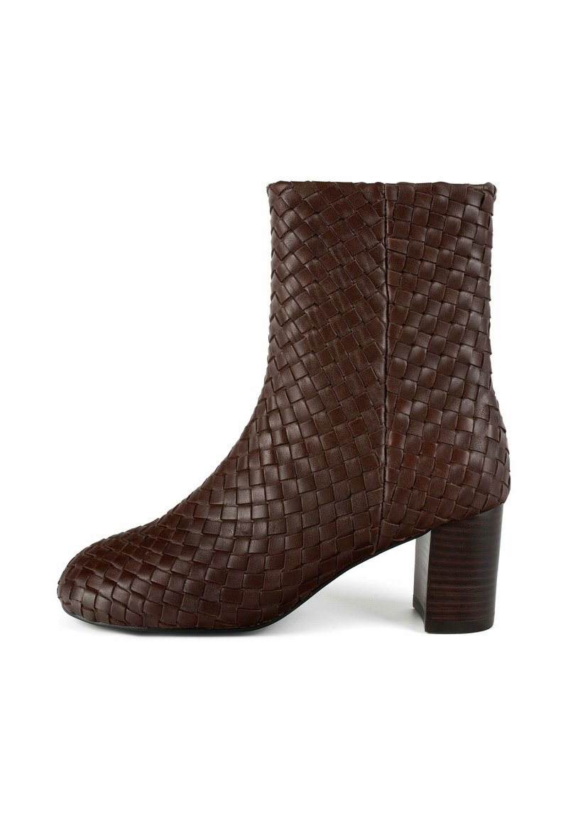 Stivaletto alla caviglia in pelle intrecciata marrone con tacco spesso, caratterizzato da una texture liscia e una silhouette aderente. Dettaglio della cucitura laterale visibile.