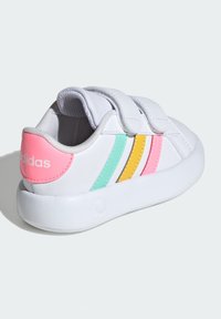 Biele atletické topánky s ružovými, mentolovými a žltými pruhmi. Majú suchý zips a vyvýšenú bielu podrážku. Hladký syntetický materiál.