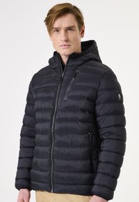 Gevulde zwarte jas met een ritssluiting aan de voorkant, afneembare capuchon, gequiltte textuur en zijzakken; heeft een logo op de linkermouw.