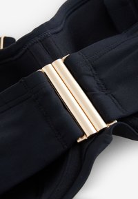 Corset de talie din material negru, cu textură netedă, design structurat și închizători metalice aurii pentru fixare sigură.