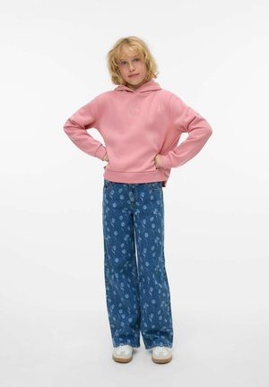 Sweat-shirt à capuche rose avec "BLA BLA" brodé sur la poitrine, associé à un jean bleu à large jambe avec un motif floral. Baskets blanches.