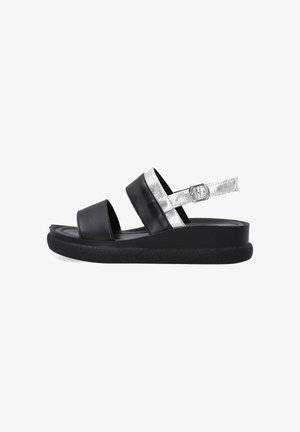 Sort platformsandal med to sorte remme og en sølvfarvet justerbar anklerem med spænde på hvid baggrund.