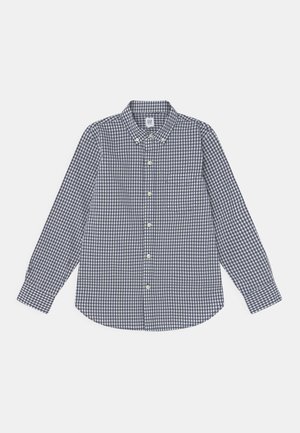 Chemise à manches longues avec motif vichy bleu marine et blanc, col boutonné et poche poitrine unique.