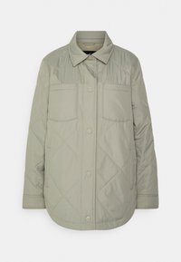 Vadderad ljusgrön jacka med krage, två bröstfickor och tryckknappar. Slät textur med synlig sömdekoration.