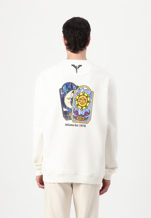 White sweatshirt with illustrations of the sun and moon on the back, featuring colorful details and the text "Milano Est 1978" below.