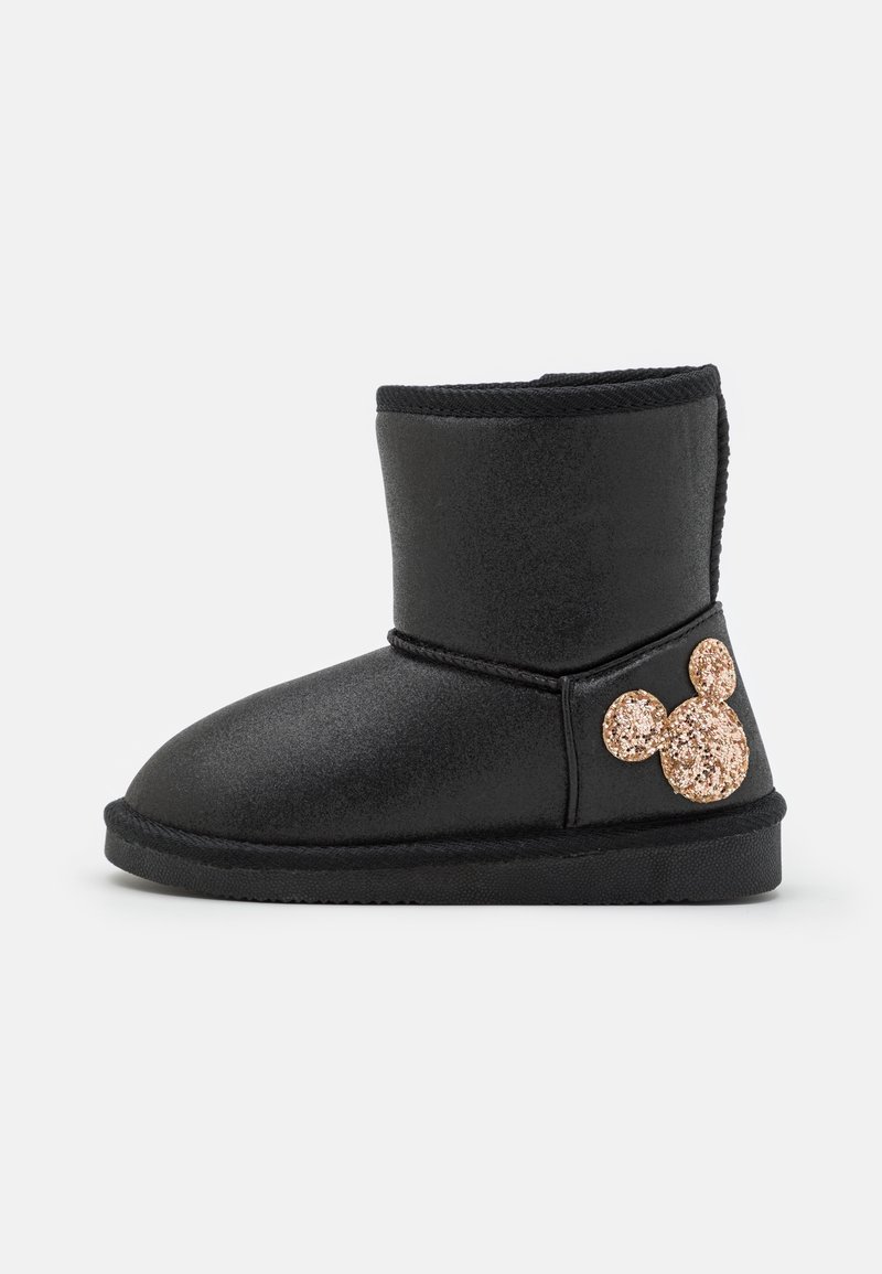 Bottine noire à semelle plate avec une silhouette scintillante de Mickey Mouse en or rose sur le côté extérieur.