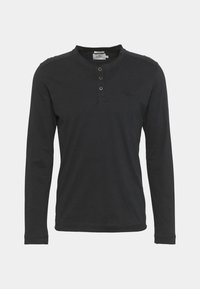 Långärmad svart henley-tröja i mjukt tyg med rund halsringning, treknappsstängning och diskret logotyp på bröstet.