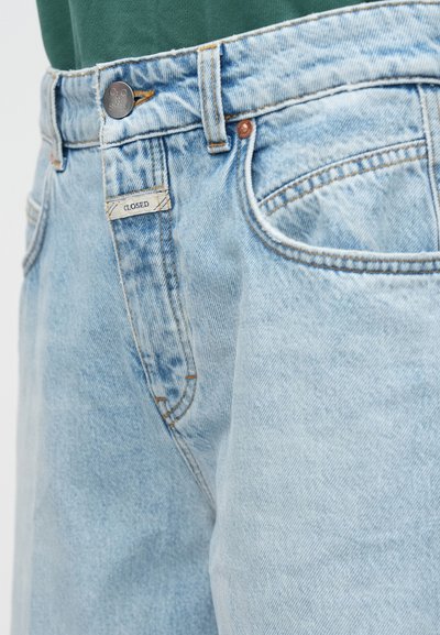Ανοιχτό μπλε τζιν παντελόνι με ξεθωριασμένο φινίρισμα, διαθέτει πέντε τσέπες, κλείσιμο με μπροστινό κουμπί και ραφές σε χρώμα κάμελ.