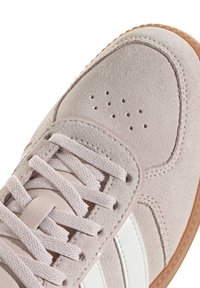 Hellrosa Veloursledersneaker mit weißen Lederstreifen, abgerundeter Spitze, Schnürdesign und perforierten Details an der Vorderseite. Gummiaußensohle.