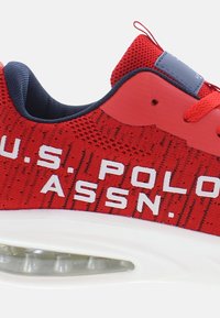 Rote Stoff-Sneaker mit weißer "U.S. POLO ASSN."-Beschriftung, strukturiertem Obermaterial, gepolstertem Kragen und einer transparenten Luftpolstersohle.