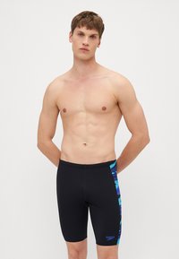 Maillot de bain noir au design ajusté, fabriqué en matériau extensible, avec une accentuation latérale à motif bleu et un logo Speedo sur la jambe.
