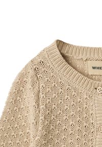 Cardigan en maille beige avec un motif texturé, col rond côtelé et deux boutons en bois clair. La laine douce est visible dans le tissu.
