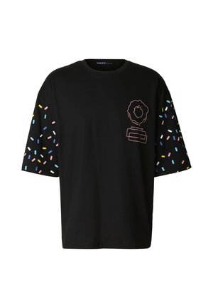 Czarny, oversize'owy t-shirt z kolorowymi wzorami posypki na rękawach oraz nadrukiem na przodzie przedstawiającym kwiat i poziome paski.