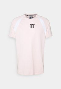 Camiseta de manga corta rosa claro con mangas blancas tipo raglán. Presenta un logo negro "11°" en la parte delantera y un cuello redondo. Material de algodón suave.
