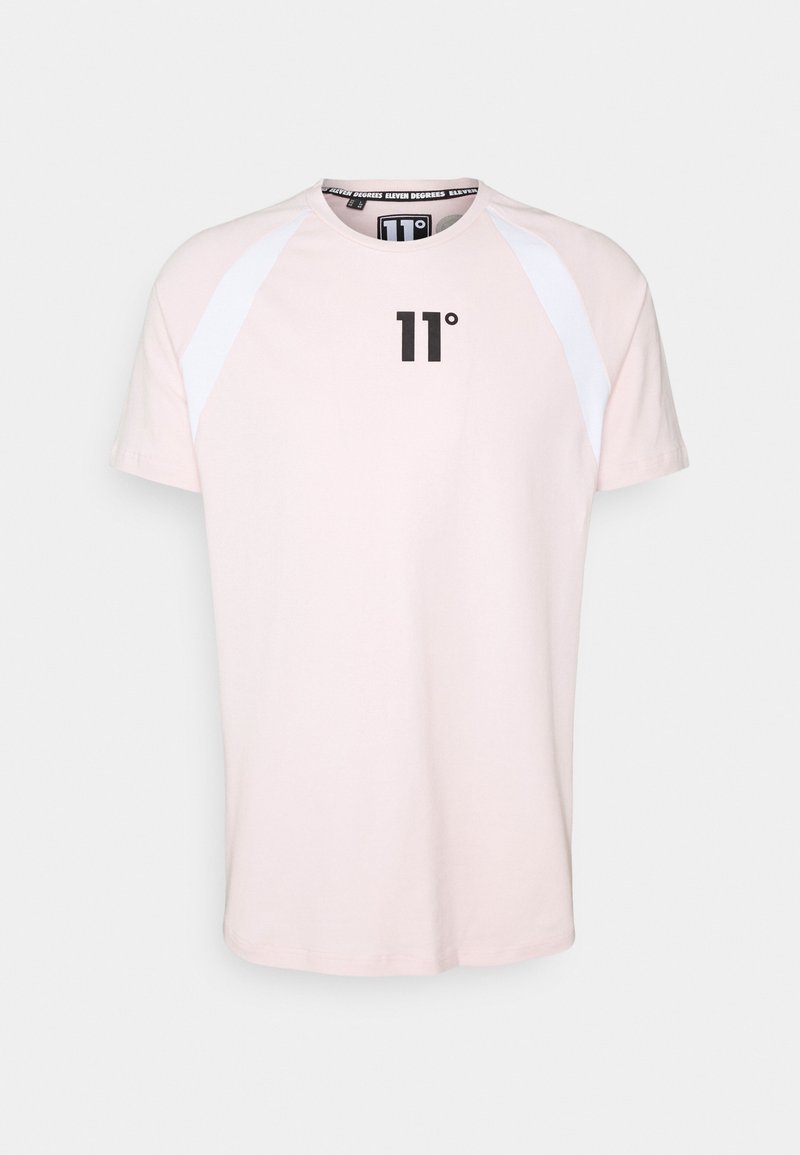 Camiseta de manga corta rosa claro con mangas blancas tipo raglán. Presenta un logo negro "11°" en la parte delantera y un cuello redondo. Material de algodón suave.