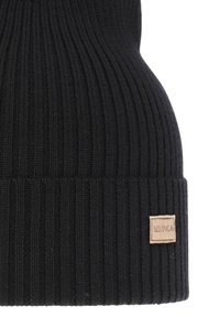 Zwarte gebreide beanie met een geribbelde structuur en een omgeslagen boord; bevat een klein beige stoffen label met merknaam.