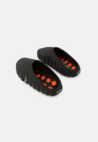 Μαύρα παπούτσια τύπου slip-on με υφή στην επιφάνεια και πορτοκαλί επένδυση στο εσωτερικό. Η σόλα έχει κυματιστό σχέδιο για καλύτ ερη πρόσφυση.