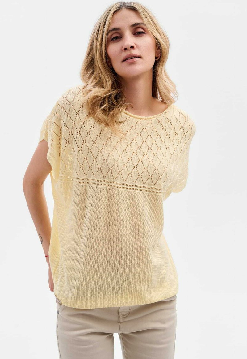 Jasnożółty sweter z dzianiny z diamentowym wzorem, szerokimi krótkimi rękawami i luźnym, teksturowanym krojem. Miękka tkanina i okrągły dekolt.