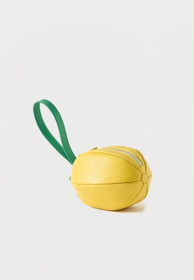 Porte-monnaie en cuir jaune en forme de citron avec une sangle verte pour le poignet et une fermeture éclair argentée sur le dessus.