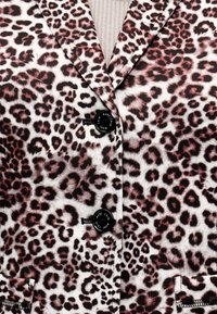 Σακάκι με κουμπιά, με καφέ και μαύρο σχέδιο λεοπάρ, και εμφανές μπεζ πλεκτό ύφασμα με ραβδώσεις από κάτω.