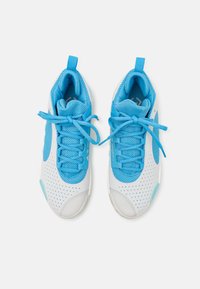 Zapatillas deportivas blancas con acentos de malla azul, punta redondeada, diseño perforado y cordones azules. Cuentan con una pestaña en el talón para facilitar su uso.