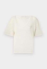 T-shirt kratkih rukava, V-izreza, izrađen od mekog kremastog materijala s opuštenim krojem, s malim zlatnim grbom na prsima. Glatka tekstura.