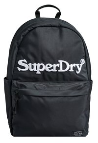 Zaino in tessuto nero con schienale imbottito, manico superiore, spallacci regolabili, tasca anteriore con zip e logo "SuperDry" bianco sul davanti.