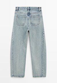 Lichtblauwe spijkerbroek plat gelegd met twee achterzakken, ceintuurlussen en zichtbare naden op een witte achtergrond.