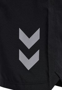 Czarne szorty z teksturowanej tkaniny, z odblaskowym srebrnym wzorem w kształcie chevronu po boku oraz widocznymi detalami szwów na końcach.