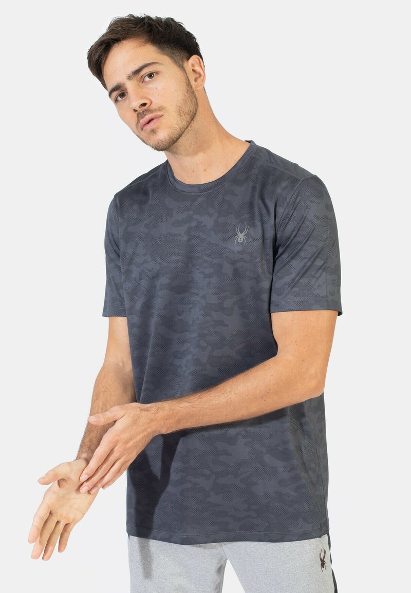 Kortærmet, mørkegrå t-shirt med camouflage mønster og et subtilt logo på brystet. Fremstillet af et glat, åndbart stof.