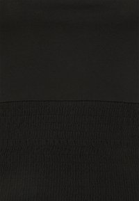 Black fabric featuring smooth texture at the top and gathered, textured smock detail at the bottom, providing a structured look.