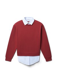 Sweatshirt rouge à manches longues, col rond et poignets côtelés, porté sur une chemise blanche à col, avec un ourlet pointu et une texture de tissu lisse.