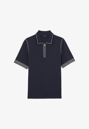 Polo cu mâneci scurte bleumarin, cu cusături contrastante albe pe guler, fenta cu fermoar și mansetele cu dungi la mâneci.