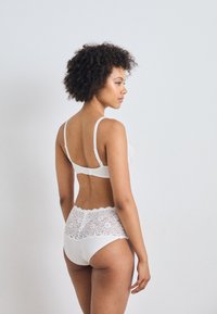 Set di reggiseno in pizzo bianco e culotte a vita alta, con un design in pizzo a onde in vita e spalline regolabili per una vestibilità sicura.