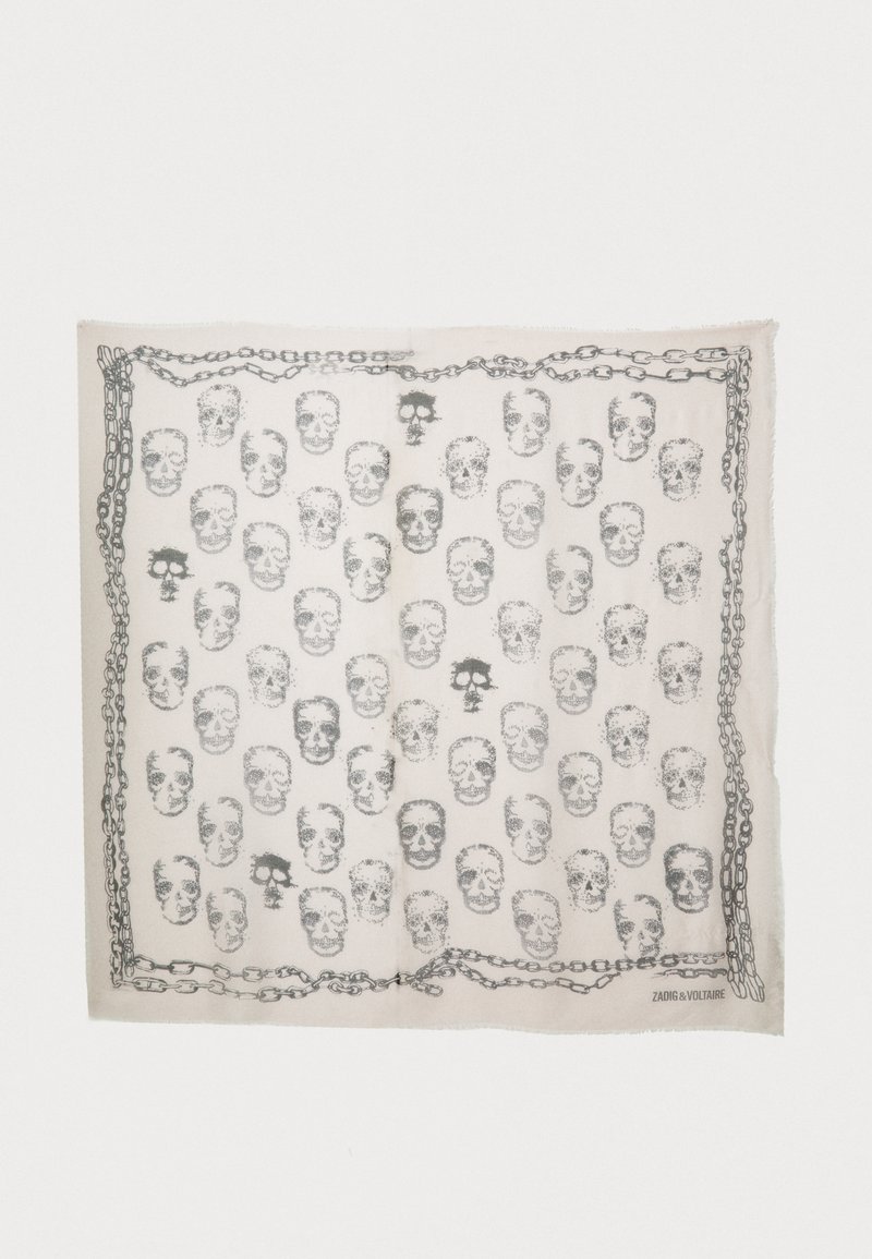 Hvit skjerf med et gjentatt mønster av hodeskaller i svart og en kjede-kant. Kantene er frynset for tekstur. Lett materiale.