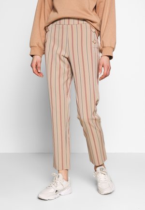 Beige gestreepte broeken met rode en marineblauwe verticale lijnen, met een hoge taille, zijknopen en een slank, cropped model. Gekocht met witte sneakers.