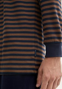 Raidallinen pitkähihais shirt, ruskeassa ja tummansinisen värissä, jossa on pehmeä tekstuuri, sivumerkki ja istuvat hihansuut.
