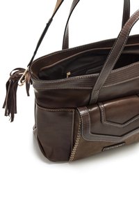 Bolso de mano de cuero marrón con un acabado texturizado, que presenta dos asas, una parte superior con cremallera y costuras visibles. Incluye un borlote decorativo.