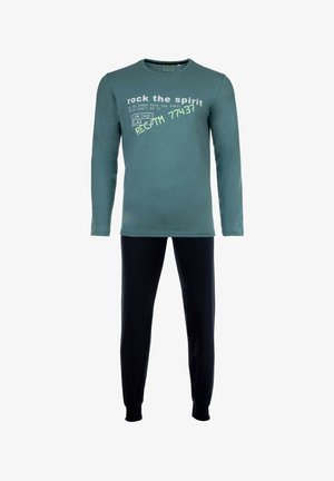 Maglietta a maniche lunghe color teal con testo bianco, abbinata a pantaloni neri. L'outfit presenta una vestibilità rilassata e un morbido tessuto di cotone.