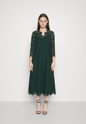 Robe midi en dentelle verte avec des manches trois-quarts et un col en dents de scie. Présente un motif de dentelle texturée et une jupe évasée.