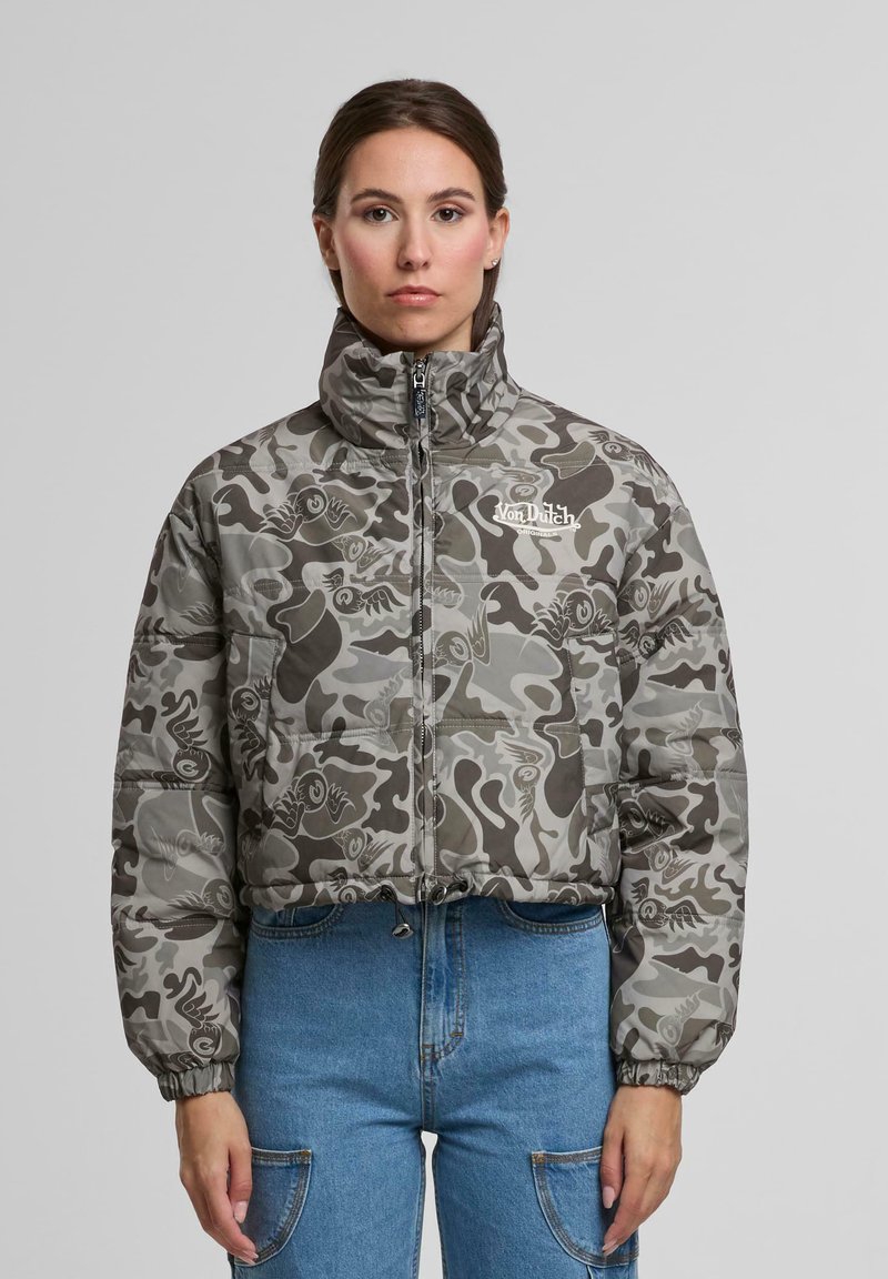 Izgriezta pūkaina jaka pelēkā kamuflāžas rakstā ar melniem akcentiem, ar augstu apkakli, rāvējslēdzēju un elastīgu aproču.